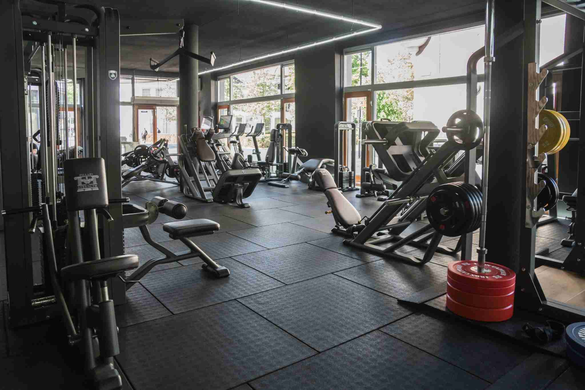 Krachtruimte van Pillars of Strength met zware apparatuur en QR-check-in